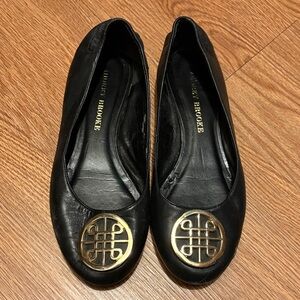 Audrey Brooke Black Flats with Gold Emblem